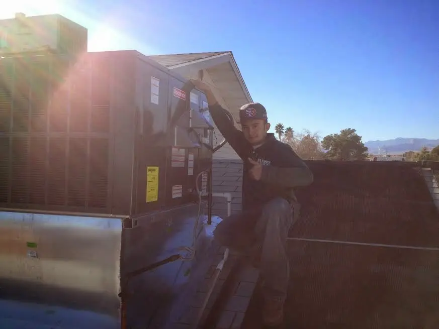 HVAC technician performing AC Tune-Up on a rooftop unit in Southeast